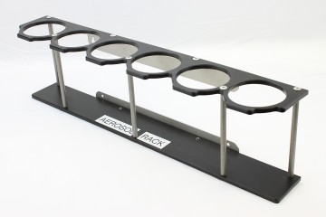 This rack holds 6 aerosol spray cans and can be attached to a work bench or trailer door.